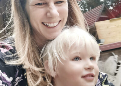 Blonde Frau mit blondem Kleinkind im Vergnügungspark